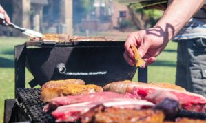 Man applying spice to steak on BBQ